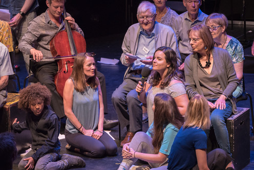 A group of women on stage with a cellist sat behind
