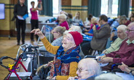 A woman in a wheelchair with her hand in the air.