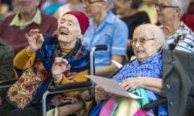 A woman in a wheelchair with her hands in the air.