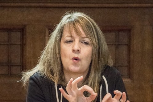 A woman using British Sign Language to sign a concert.