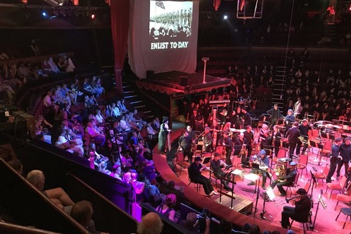 Hundreds of young people performing in a circular venue.
